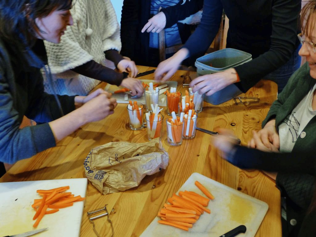 Atelier programmé de préparation culinaire, des participant(e)s font des bâtonnets de légumes frais